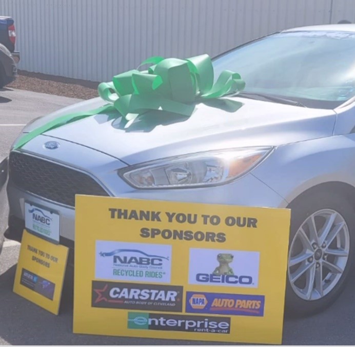 Ford Focus with a green bow and a Thank You to our sponsors sign