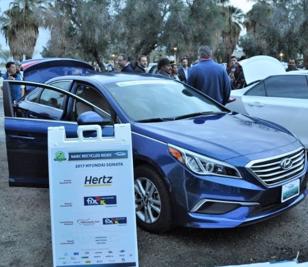 Hyundai Sonata with NABC Recycled Rides sign, Hertz logo is the most prominent on sign